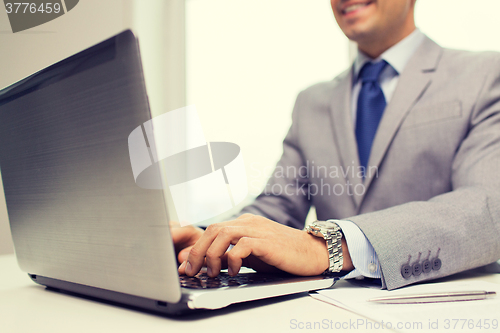 Image of close up of businessman with laptop and papers