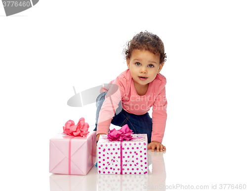 Image of baby girl with birthday presents and confetti