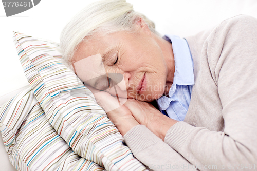 Image of happy senior woman sleeping on pillow at home