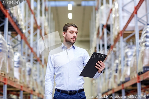 Image of businessman with clipboard at warehouse