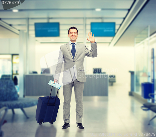 Image of happy businessman in suit with travel bag