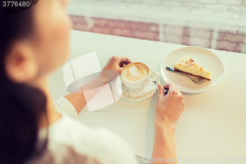 Image of close up of woman hands with cake and coffee