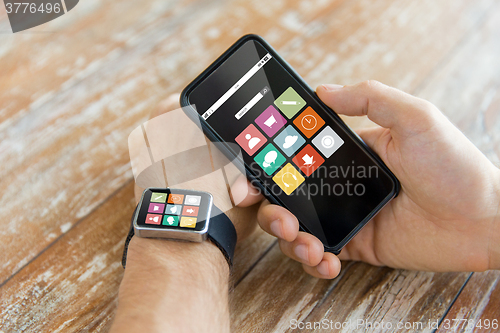 Image of close up of hands with smart phone and watch