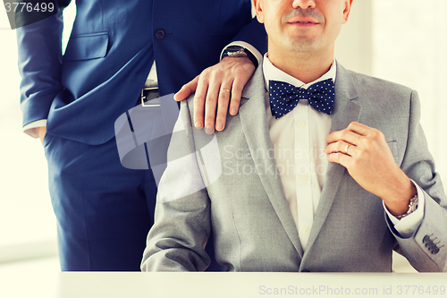 Image of close up of male gay couple with wedding rings on