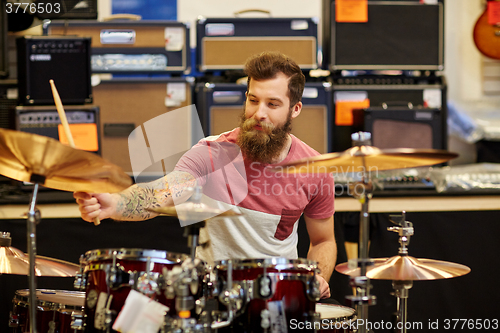 Image of male musician playing cymbals at music store