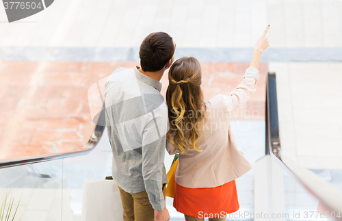 Image of happy young couple with shopping bags in mall