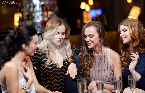 Image of woman showing engagement ring to her friends