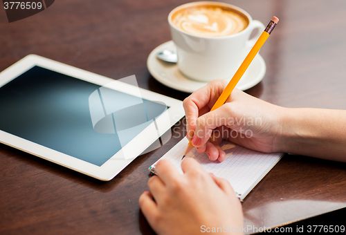 Image of close up of woman writing to notebook with pencil