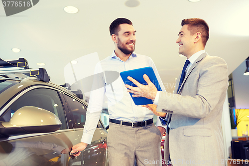 Image of happy man with car dealer in auto show or salon