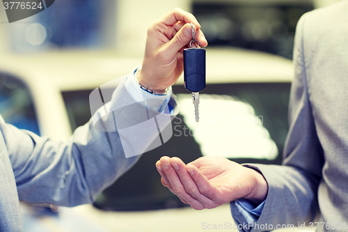 Image of close up of male hands with car key in auto salon