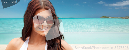 Image of smiling young woman with sunglasses on beach