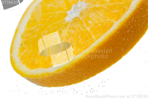 Image of orange slice falling or dipping in water