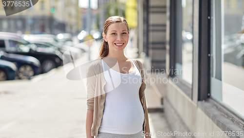 Image of happy smiling pregnant woman at city street