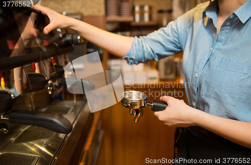 Image of close up of woman making coffee by machine at cafe