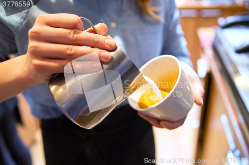 Image of close up of woman making coffee at shop or cafe