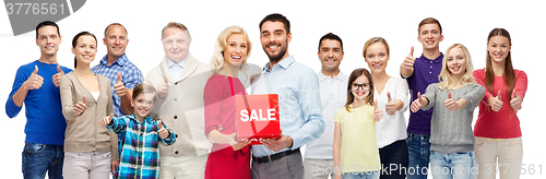 Image of happy people with red sale sign showing thumbs up