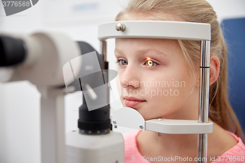 Image of girl checking vision with tonometer at eye clinic