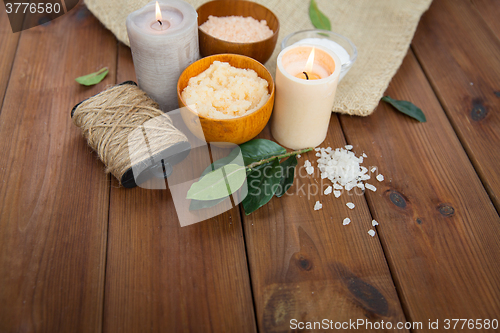 Image of close up of natural body scrub and candles on wood