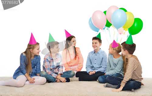 Image of happy smiling children in party hats on birthday