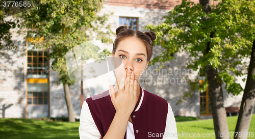 Image of confused student girl covering her mouth by hand