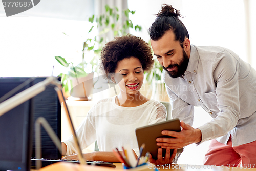 Image of happy creative team with tablet pc in office