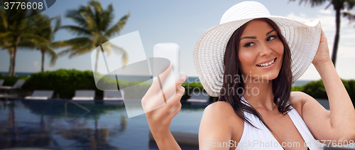 Image of young woman taking selfie with smartphone