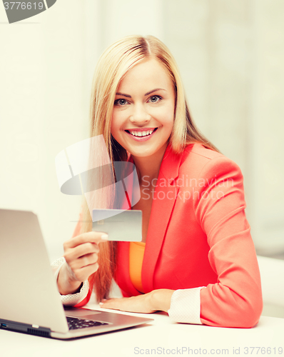 Image of businesswoman with laptop using credit card