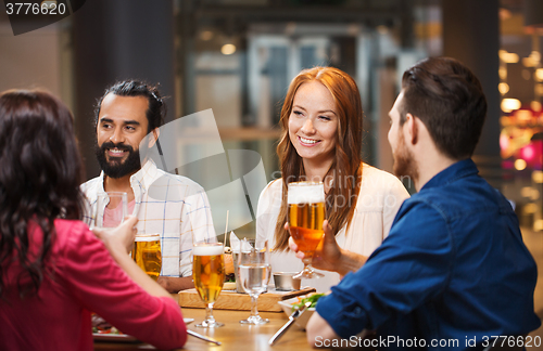 Image of friends dining and drinking beer at restaurant