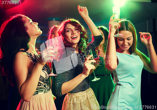 Image of smiling friends with glasses of champagne in club