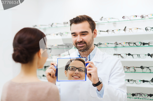 Image of woman in glasses looking to mirror at optics store