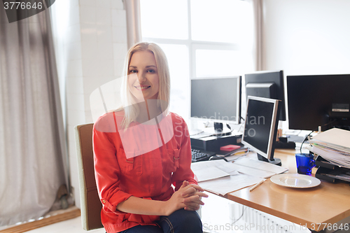Image of happy creative female office worker with computers