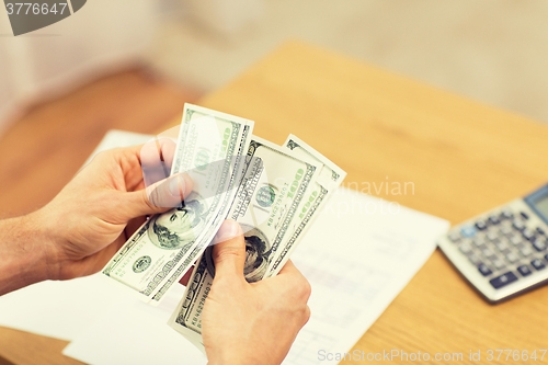 Image of close up of man hands counting money at home