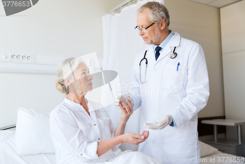 Image of doctor giving medicine to senior woman at hospital