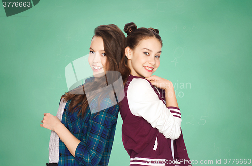 Image of happy pretty teenage girls over green school board
