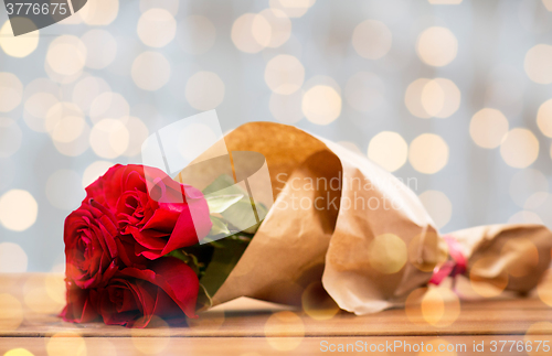 Image of close up of red roses bunch wrapped into paper