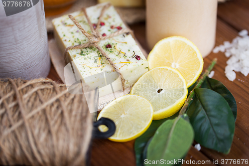 Image of close up of natural soap and candles on wood