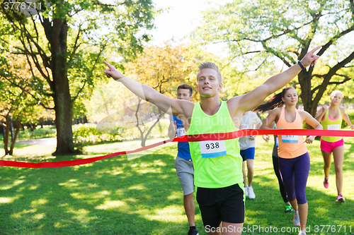 Image of happy young male runner winning on race finish