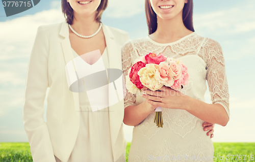 Image of close up of happy lesbian couple with flowers