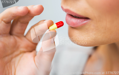 Image of close up of woman taking medicine in pill