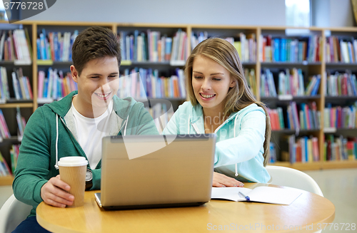 Image of happy students with laptop in library