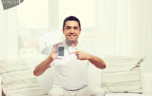 Image of happy man with smartphone at home