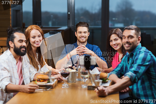 Image of friends taking selfie by smartphone at restaurant