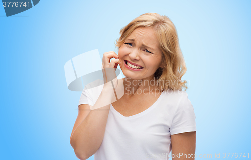 Image of unhappy woman suffering from face inch