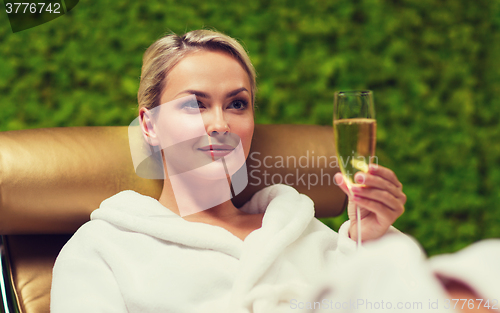 Image of beautiful young woman drinking champagne at spa