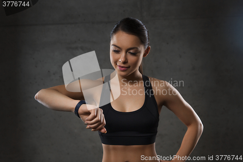 Image of young woman with heart-rate watch in gym