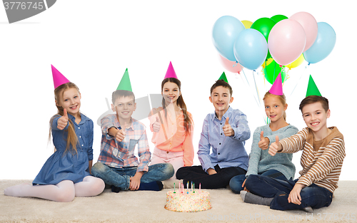 Image of happy children in party hats with birthday cake