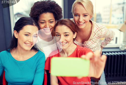 Image of happy young women taking selfie with smartphone