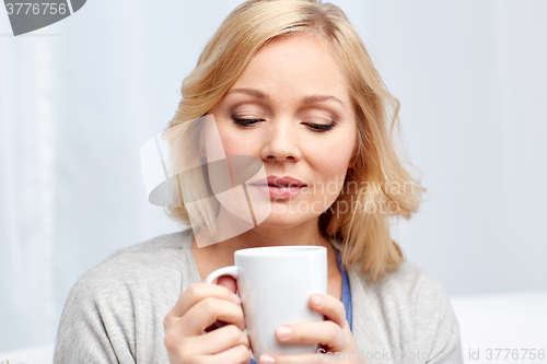 Image of woman with cup of tea or coffee at home