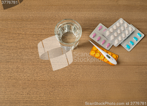 Image of Thermometer, pills and glass of water