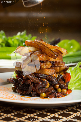 Image of fried potatoes with meat. 